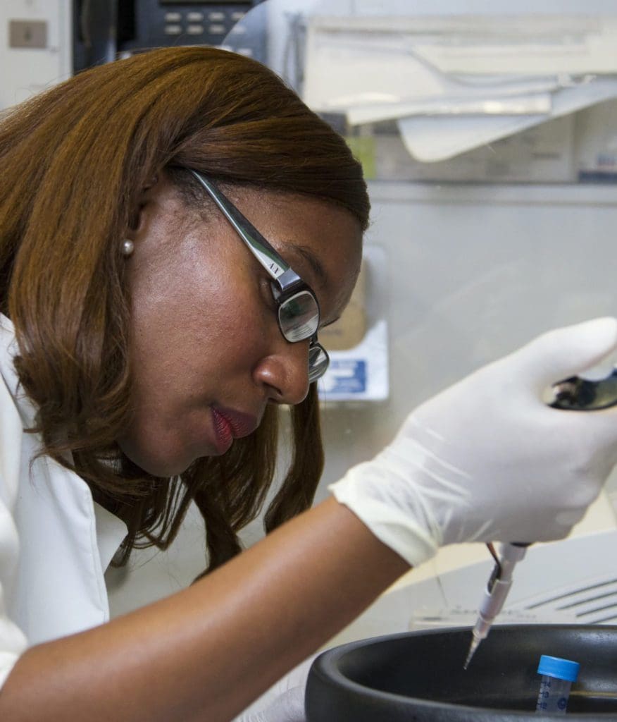 Woman with glasses using a research instrument in a lab