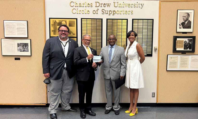 Kibebe Gizaw, McMillan-Stewart Foundation President, delivers two checks – $400,000 for scholarships and $200,000 for SSA II – to CDU staff.