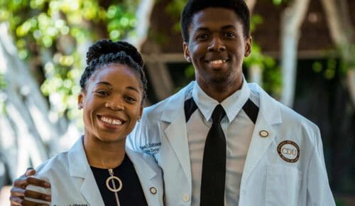 Two white coat students smiling