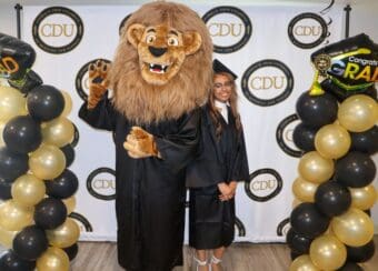 CDU student with Drew the Mascot during Gradfest 2024.