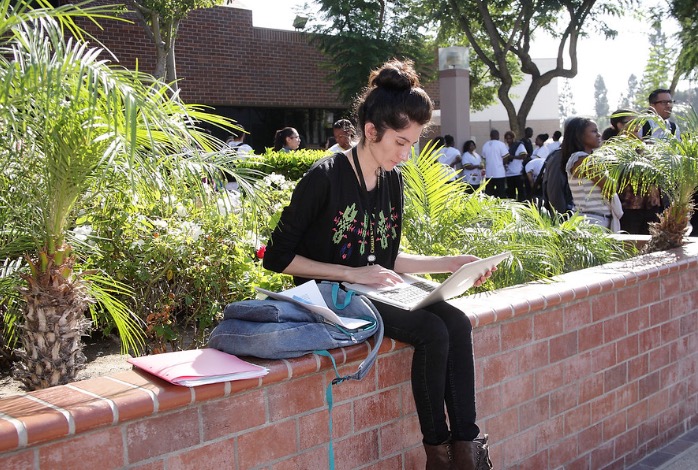 Woman sitting on brick wall